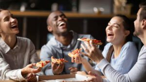 happy people eating catered pizza